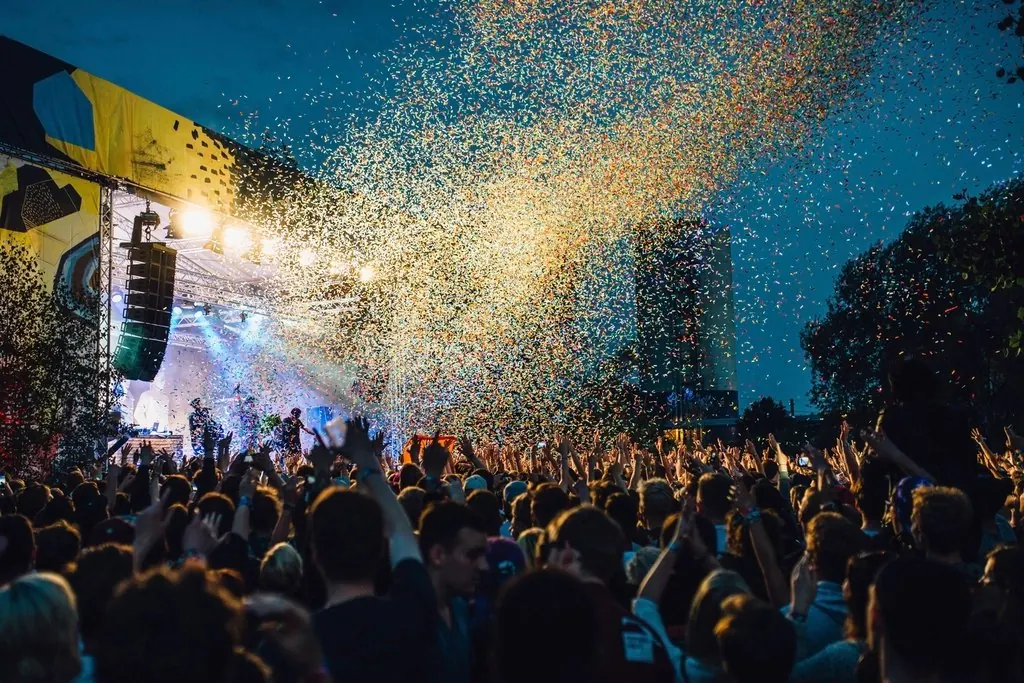 Público frente al escenario de un festival con confeti
