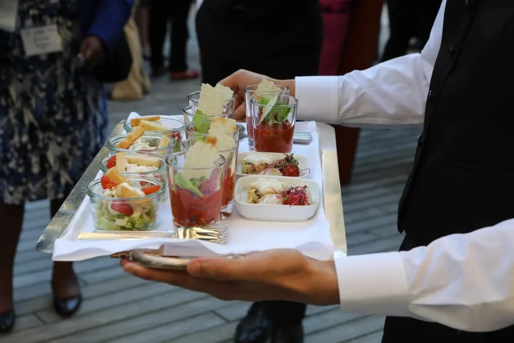 Camarero sirviendo una bandeja de aperitivos en un evento